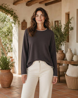 Mulher veste camisola de malha fina cinzenta Maria Pailona com detalhes em contraste na gola e punhos, estilo casual.