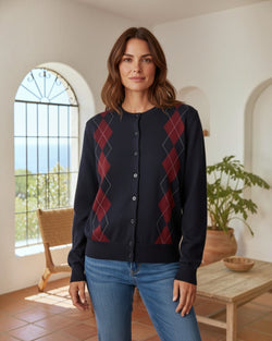 Modelo veste cardigan Maria Pailona azul-marinho com padrão argyle em bordô, malha suave com botões e punhos canelados.